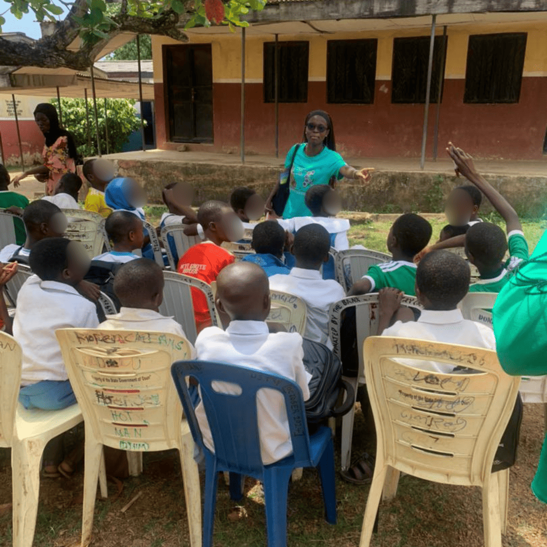 lady in front of school girls speaking to them