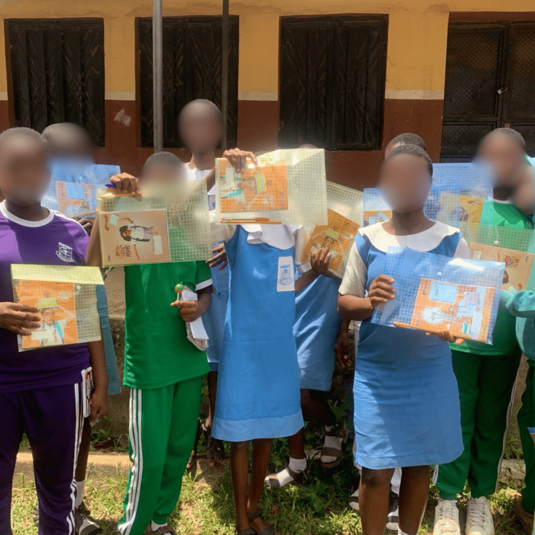 girls in school holding a file bag containing book, pen and pencil